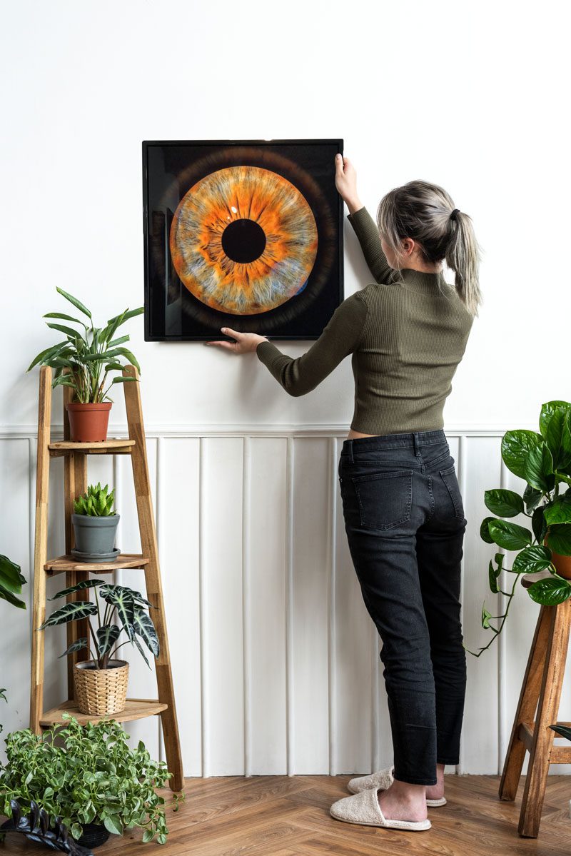 young-woman-hanging-frame-on-the-wall